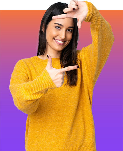 Lächelnde junge Frau, die mit ihren Händen ein Rechteckt vor ihrem Gesicht formt